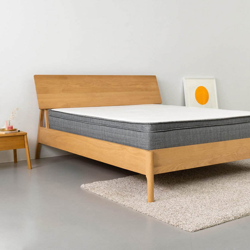 Origin Mattress in bedroom with wooden side table and rug under the bed